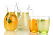 Orange and lemon lemonade in pitchers and glasses isolated