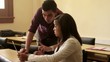 Students talking and using laptop computer in college class
