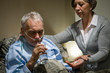 Senior man taking medication with water