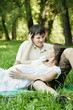 Pregnant wife and her loved husband lying on green grass
