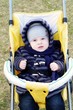 Photo: nice baby outdoors on yellow baby carriage in spring nice baby outdoors on yellow baby carriage in spring