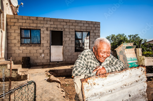 Photo: Man in front of his township house Man in front of his township house