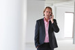 Business man calling with his cellphone in white office.