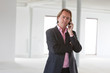 Business man calling with his cellphone in white office.