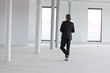 Business man in crisis walking and calling in empty office.