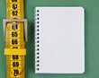 Photo: meter belt slimming and notepad on the green background meter belt slimming and notepad on the green background