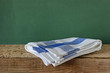Table-napkin and old wooden deck table with green grunge backgro