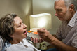 Loving retired husband feeding his ill wife