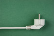 Photo: white electrical cable with plug on the green background white electrical cable with plug on the green background