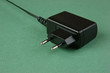Photo: black charger adapter with plug on the green background black charger adapter with plug on the green background