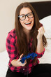 Photo: Young woman in casual playing videogame Young woman in casual playing videogame