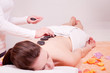 junge attraktve frau bekommt eine hot stone massage zur entspann