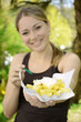 Foto: Junge Frau zeigt Schale mit Pommes Frites Junge Frau zeigt Schale mit Pommes Frites