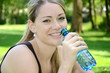Junge Frau trinkt Wasser im Park