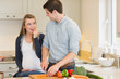 Man cutting vegetables for his pregnant wife