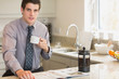Man drinking coffee while reading newspaper