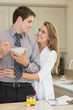 Man eats cereal while partner is embracing him
