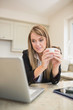 Photo: Woman drinking a coffee while working with multimedia Woman drinking a coffee while working with multimedia