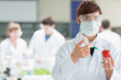 Foto: Woman standing at the laboratory injecting a tomato Woman standing at the laboratory injecting a tomato