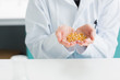 Foto: Student in lab coat holding grain Student in lab coat holding grain