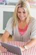Laughing young woman working on tablet