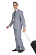 Foto: Smiling businessman walking with his suitcase Smiling businessman walking with his suitcase