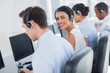 Attractive call centre employee looking over shoulder