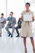 Foto: Smiling businesswoman standing and holding a blank notice Smiling businesswoman standing and holding a blank notice