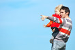 Happy father and son playing on sky background