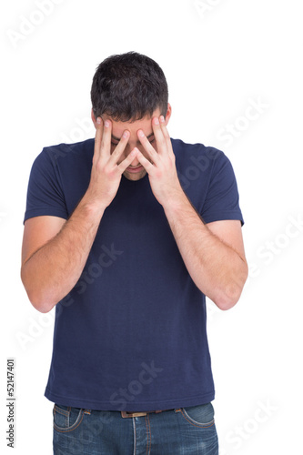Photo: Upset man standing with his head in hands Upset man standing with his head in hands