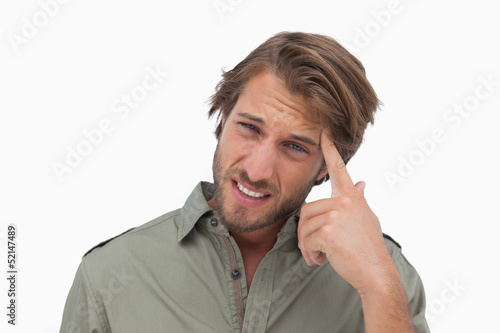 Photo: Man with headache touching his head and looking at camera Man with headache touching his head and looking at camera
