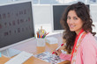 Editor marking the contact sheet and smiling at camera