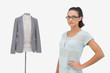 Fashion designer posing beside clothes mannequin