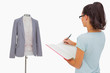 Designer looking at her mannequin and taking notes