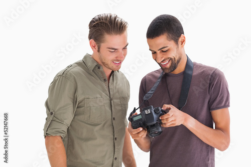 Photo: Stylish men looking at digital camera Stylish men looking at digital camera