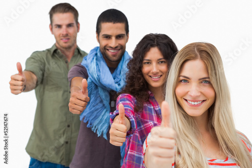 Photo: Friends giving thumbs up in a row Friends giving thumbs up in a row