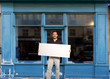 Photo : Man with sign by shop Man with sign by shop