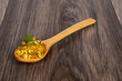 spoon full of tablets on wooden table