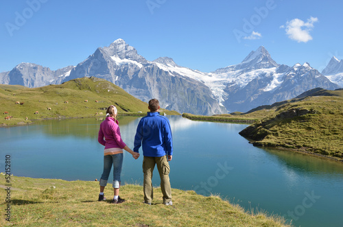 Photo: Travelers enjoying Alpine panorama. Jungfrau region, Switzerland Travelers enjoying Alpine panorama. Jungfrau region, Switzerland