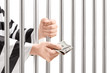 Foto: Man in jail holding prison bars and giving bribe Man in jail holding prison bars and giving bribe