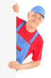 Mature repairman smiling and posing behind a blank panel