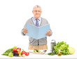 Middle aged gentleman reading a cookbook during a preparation of