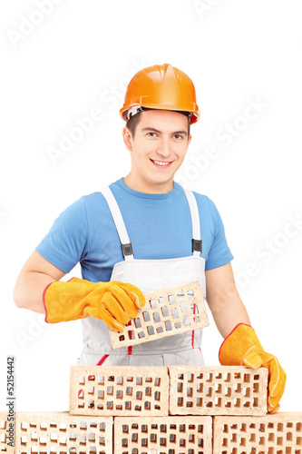 Photo: Male manual worker building a brick wall Male manual worker building a brick wall
