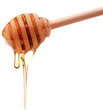 Honey dripping from a wooden honey dipper isolated on white back