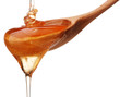 Honey dripping from a wooden honey dipper isolated on white back