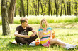 Cute young couple having food on picnic