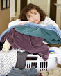 Unhappy  woman resting on messy pile of laundry