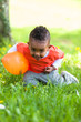 Outdoor portrait of a cute young  little black boy playing with