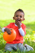 Outdoor portrait of a cute young  little black boy playing with
