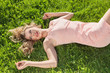 Foto: Young woman lying on grass Young woman lying on grass